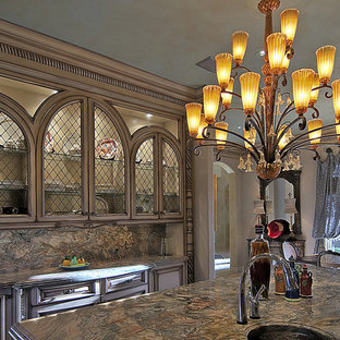 Idée de décoration pour une grand cuisine américaine méditerranéenne en U avec un évier 3 bacs, un placard avec porte à panneau encastré, des portes de placard beiges, un plan de travail en granite, une crédence grise, une crédence en dalle de pierre, un électroménager en acier inoxydable, un sol en carrelage de céramique, un îlot central et un sol marron.