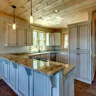 This is an example of a large country u-shaped open plan kitchen in Atlanta with an undermount sink, louvered cabinets, white cabinets, granite benchtops, white splashback, stainless steel appliances, medium hardwood floors and a peninsula.