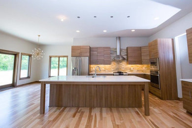 Example of a mid-sized trendy l-shaped light wood floor and beige floor eat-in kitchen design in Milwaukee with a double-bowl sink, flat-panel cabinets, white cabinets, quartzite countertops, beige backsplash, stainless steel appliances and an island