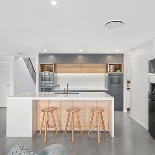 Design ideas for a mid-sized modern l-shaped open plan kitchen in Gold Coast - Tweed with an undermount sink, flat-panel cabinets, grey cabinets, quartz benchtops, white splashback, stone slab splashback, coloured appliances, porcelain floors, with island, grey floor and white benchtop.