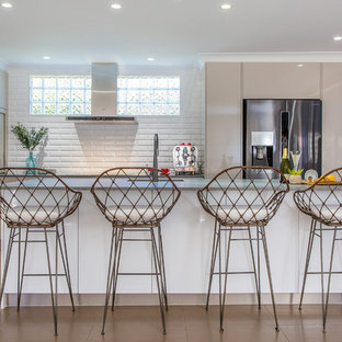 Design ideas for a large beach style l-shaped open plan kitchen in Brisbane with beige cabinets, white splashback, subway tile splashback, stainless steel appliances, with island, beige floor, grey benchtop, an undermount sink, quartz benchtops and porcelain floors.
