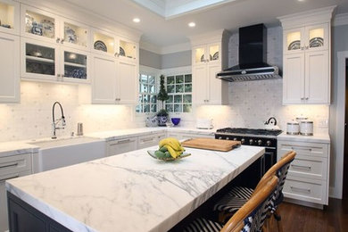 サンフランシスコにある高級な中くらいなトラディショナルスタイルのおしゃれなキッチン (エプロンフロントシンク、フラットパネル扉のキャビネット、白いキャビネット、大理石カウンター、白いキッチンパネル、サブウェイタイルのキッチンパネル、パネルと同色の調理設備、濃色無垢フローリング、茶色い床、白いキッチンカウンター) の写真