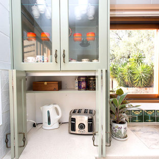 Design ideas for a small country galley kitchen in Other with a double-bowl sink, shaker cabinets, green cabinets, solid surface benchtops, white splashback, metal splashback, slate floors, multi-coloured floor and beige benchtop.