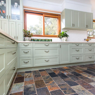 Photo of a small country galley kitchen in Other with a double-bowl sink, shaker cabinets, green cabinets, solid surface benchtops, white splashback, metal splashback, slate floors, multi-coloured floor and beige benchtop.