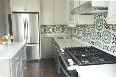 Inspiration for a mid-sized eclectic galley ceramic tile and brown floor enclosed kitchen remodel in Baltimore with an undermount sink, recessed-panel cabinets, green cabinets, quartz countertops, multicolored backsplash, cement tile backsplash, stainless steel appliances and an island