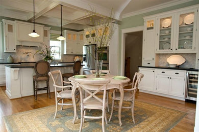 Klassisk inredning av ett stort kök, med en rustik diskho, luckor med profilerade fronter, vita skåp, bänkskiva i täljsten, vitt stänkskydd, stänkskydd i stenkakel, rostfria vitvaror, mellanmörkt trägolv och en köksö