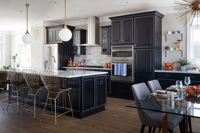 Idéer för ett klassiskt kök och matrum, med luckor med upphöjd panel, grått stänkskydd, rostfria vitvaror, ljust trägolv, en köksö, granitbänkskiva och stänkskydd i marmor