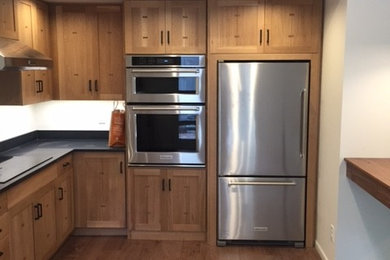 Example of a large mid-century modern u-shaped medium tone wood floor open concept kitchen design in Other with a single-bowl sink, recessed-panel cabinets, light wood cabinets, granite countertops, black backsplash, stainless steel appliances and a peninsula