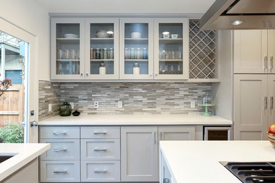 Kitchen - transitional kitchen idea in Los Angeles with shaker cabinets, quartzite countertops, gray backsplash, stone tile backsplash and an island
