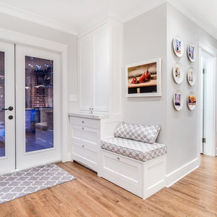 Photo of a mid-sized traditional galley eat-in kitchen in Vancouver with a farmhouse sink, shaker cabinets, white cabinets, quartz benchtops, yellow splashback, stone tile splashback, stainless steel appliances, medium hardwood floors and a peninsula.