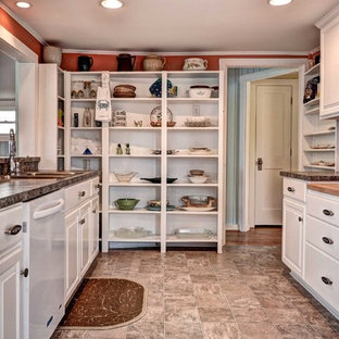 Small beach style galley separate kitchen in Other with a double-bowl sink, raised-panel cabinets, white cabinets, granite benchtops, white appliances, ceramic floors, no island and brown floor.