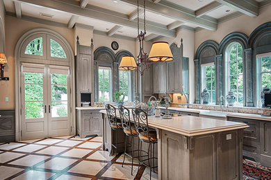Eat-in kitchen - huge mediterranean single-wall travertine floor eat-in kitchen idea in Other with an island, a farmhouse sink, recessed-panel cabinets, gray cabinets, granite countertops, beige backsplash, glass tile backsplash and stainless steel appliances