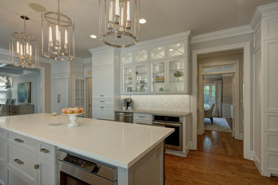Eat-in kitchen - large transitional medium tone wood floor eat-in kitchen idea in New York with a farmhouse sink, shaker cabinets, white cabinets, quartzite countertops, white backsplash, marble backsplash, an island and white countertops