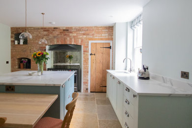 Design ideas for a traditional l-shaped kitchen/diner in Buckinghamshire with a built-in sink, shaker cabinets, green cabinets, tile countertops, stainless steel appliances, limestone flooring, an island, beige floors and white worktops.