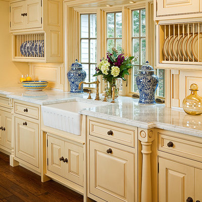 Elegant dark wood floor eat-in kitchen photo in Bridgeport with a farmhouse sink, marble countertops, beaded inset cabinets, yellow cabinets and an island