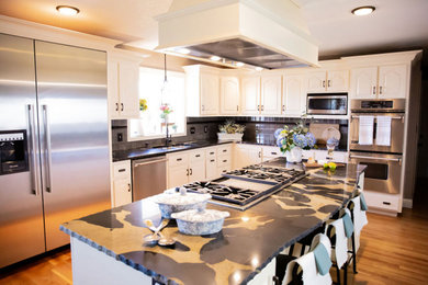 Example of a large transitional l-shaped medium tone wood floor and brown floor eat-in kitchen design in Boston with a double-bowl sink, recessed-panel cabinets, white cabinets, granite countertops, beige backsplash, glass tile backsplash, stainless steel appliances, an island and white countertops