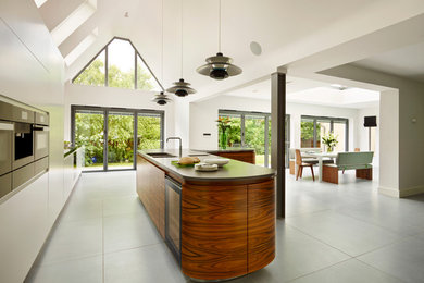 Inspiration for a contemporary l-shaped eat-in kitchen remodel in London with flat-panel cabinets and an island