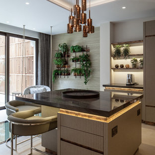 Design ideas for a contemporary kitchen in London with flat-panel cabinets, beige cabinets, an island, beige floors and brown worktops.