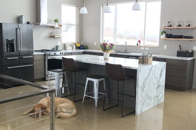 Immagine di una grande cucina contemporanea con ante lisce, ante grigie, top in laminato, elettrodomestici in acciaio inossidabile, pavimento in cemento, pavimento grigio e top bianco