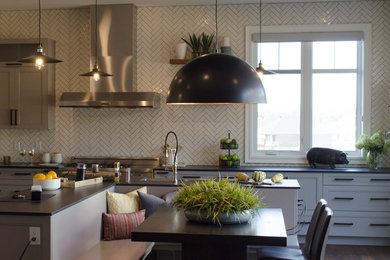 Example of a large trendy l-shaped eat-in kitchen design in Ottawa with white backsplash, ceramic backsplash, stainless steel appliances and an island