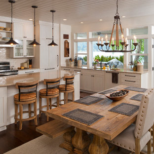 Ejemplo de cocina comedor en L, marinera, con armarios estilo shaker, puertas de armario blancas, salpicadero blanco, salpicadero de azulejos tipo metro, suelo de madera oscura y una isla