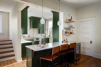 Small transitional l-shaped medium tone wood floor eat-in kitchen photo in Louisville with a single-bowl sink, recessed-panel cabinets, green cabinets, quartzite countertops, gray backsplash, stone slab backsplash, stainless steel appliances, a peninsula and gray countertops