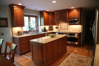 Exempel på ett stort klassiskt kök, med en dubbel diskho, luckor med upphöjd panel, skåp i mörkt trä, granitbänkskiva, flerfärgad stänkskydd, stänkskydd i mosaik, rostfria vitvaror, en köksö, mörkt trägolv och brunt golv