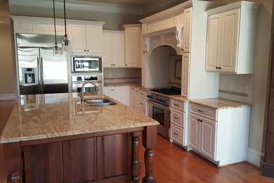 Kitchen - transitional kitchen idea in Raleigh with white cabinets and an island