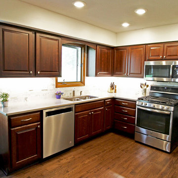 Cherry Cabinets with Beige Countertops and Calacutta Marble Backsplash