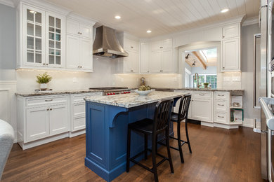 Example of a mid-sized classic u-shaped medium tone wood floor and brown floor eat-in kitchen design in Denver with an undermount sink, shaker cabinets, white cabinets, granite countertops, white backsplash, ceramic backsplash, stainless steel appliances, an island and gray countertops