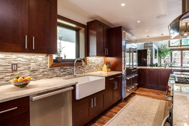 Example of a large transitional l-shaped light wood floor open concept kitchen design in Denver with a farmhouse sink, flat-panel cabinets, dark wood cabinets, granite countertops, multicolored backsplash, subway tile backsplash, stainless steel appliances and an island