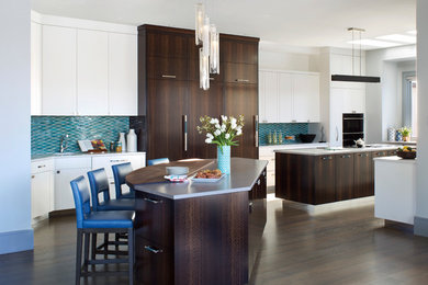 Moderne Wohnküche in U-Form mit flächenbündigen Schrankfronten, dunklen Holzschränken, Küchenrückwand in Blau, Rückwand aus Keramikfliesen, schwarzen Elektrogeräten, dunklem Holzboden, zwei Kücheninseln und grauer Arbeitsplatte in Denver