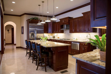 Large minimalist u-shaped porcelain tile and beige floor open concept kitchen photo in Other with an undermount sink, raised-panel cabinets, dark wood cabinets, granite countertops, beige backsplash, matchstick tile backsplash, stainless steel appliances, an island and multicolored countertops