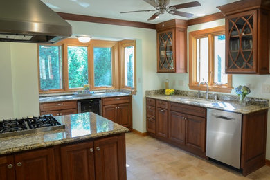 Kitchen - traditional kitchen idea in Milwaukee with raised-panel cabinets, medium tone wood cabinets and granite countertops