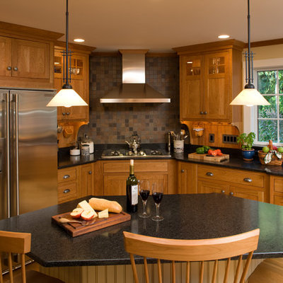Example of an arts and crafts l-shaped kitchen design in Boston with shaker cabinets, medium tone wood cabinets, granite countertops, brown backsplash, stainless steel appliances and slate backsplash