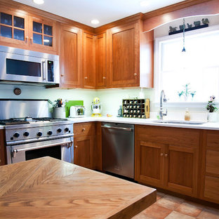 Inspiration for a large timeless l-shaped terra-cotta tile and red floor eat-in kitchen remodel in Boston with an undermount sink, shaker cabinets, dark wood cabinets, solid surface countertops, stainless steel appliances and an island