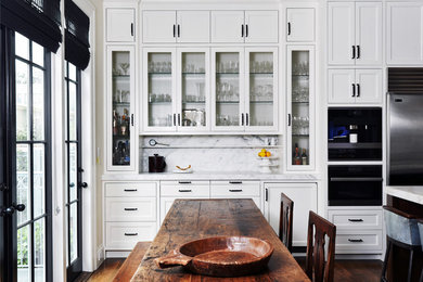 Eat-in kitchen - transitional dark wood floor and brown floor eat-in kitchen idea in San Francisco with recessed-panel cabinets, white backsplash, stainless steel appliances, marble countertops, marble backsplash and an island