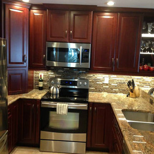 Photo of a large asian u-shaped kitchen pantry in Miami with dark wood cabinets, granite benchtops, glass tile splashback, stainless steel appliances, a double-bowl sink, raised-panel cabinets, brown splashback, ceramic floors and a peninsula.