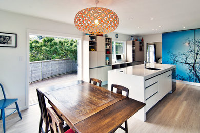 Источник вдохновения для домашнего уюта: кухня среднего размера в современном стиле с обеденным столом, плоскими фасадами и белыми фасадами