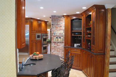 Mid-sized arts and crafts u-shaped ceramic tile eat-in kitchen photo in Boston with an undermount sink, raised-panel cabinets, medium tone wood cabinets, limestone countertops, stainless steel appliances and a peninsula