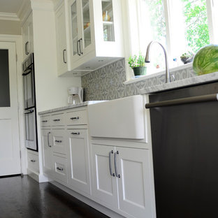 Transitional single-wall dark wood floor eat-in kitchen photo in New York with a farmhouse sink, shaker cabinets, gray cabinets, marble countertops, gray backsplash, cement tile backsplash, stainless steel appliances and an island