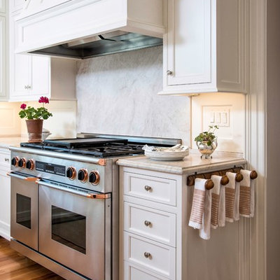 Eat-in kitchen - large traditional l-shaped medium tone wood floor eat-in kitchen idea in DC Metro with an undermount sink, beaded inset cabinets, white cabinets, limestone countertops, white backsplash, stainless steel appliances and an island
