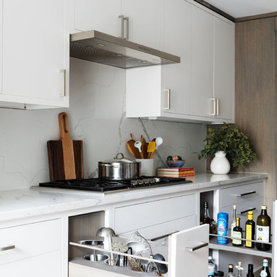 Inspiration for a mid-sized contemporary single-wall light wood floor and beige floor open concept kitchen remodel in New York with flat-panel cabinets, light wood cabinets, quartz countertops, white backsplash, marble backsplash, stainless steel appliances, an island and white countertops