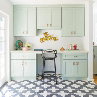 Photo of a traditional kitchen/diner in Los Angeles with shaker cabinets, green cabinets, engineered stone countertops, black appliances and light hardwood flooring.