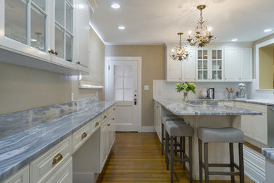 Small romantic u-shaped kitchen in Tampa with a built-in sink, raised-panel cabinets, white cabinets, marble worktops, white splashback, ceramic splashback, white appliances, medium hardwood flooring and no island.