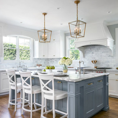 Example of a classic l-shaped dark wood floor and brown floor kitchen design in San Francisco with an undermount sink, recessed-panel cabinets, gray cabinets, white backsplash, marble backsplash, stainless steel appliances and an island