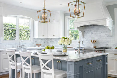 Example of a classic l-shaped dark wood floor and brown floor kitchen design in San Francisco with an undermount sink, recessed-panel cabinets, gray cabinets, white backsplash, marble backsplash, stainless steel appliances and an island