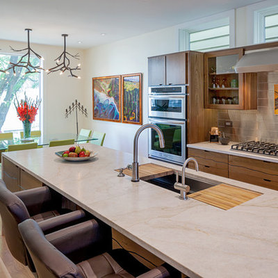 Inspiration for a contemporary galley medium tone wood floor eat-in kitchen remodel in Chicago with an undermount sink, flat-panel cabinets, medium tone wood cabinets, metallic backsplash, metal backsplash, stainless steel appliances, marble countertops and beige countertops