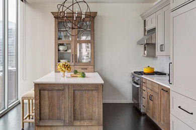 Transitional dark wood floor kitchen photo in Chicago with shaker cabinets, beige cabinets, white backsplash, stainless steel appliances, a peninsula and white countertops