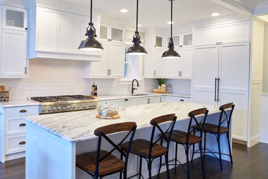 Large transitional l-shaped dark wood floor eat-in kitchen photo in Chicago with an undermount sink, white cabinets, granite countertops, white backsplash, subway tile backsplash, paneled appliances, an island and recessed-panel cabinets